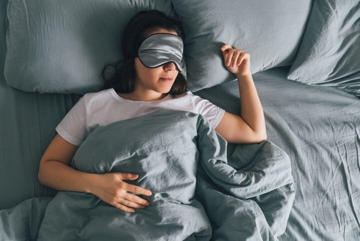 woman in bed with sleep mask