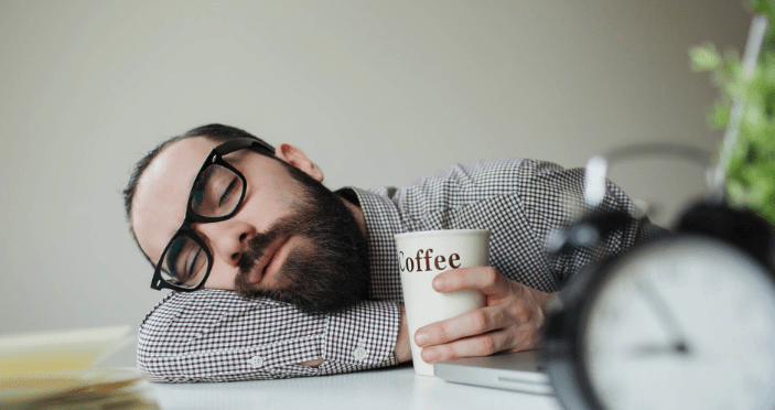 sleeping man with coffee cup